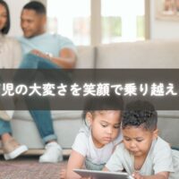 赤ちゃんを抱っこしながら上の子と遊ぶママ
