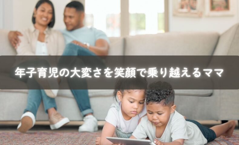 赤ちゃんを抱っこしながら上の子と遊ぶママ