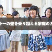 ランドセルを背負い登校する子どもと見送る母親